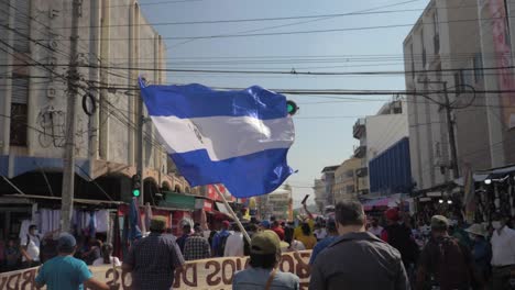 Person-Schwenkt-Während-Eines-Friedlichen-Protests-In-Den-Straßen-Der-Stadt-Gegen-Den-Derzeitigen-Präsidenten-Nayib-Bukele-Eine-Salvadorianische-Flagge---Zeitlupe