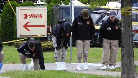FBI-cops-looking-around-for-clues-or-bullet-shells-on-the-ground-after-Mass-race-shooting-in-Buffalo,-NY,-USA---May-17th-2022