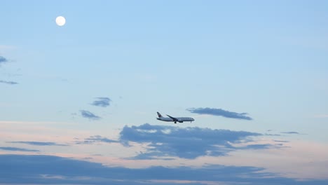 Avión-De-Pasajeros-Distante-Vuela-Bajo-La-Luna-En-El-Cielo-Nublado