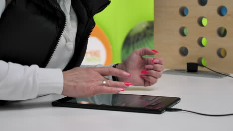 Close-up-view-of-woman-hands-with-a-digital-tablet-using-apps-typing-online-in-slow-motion
