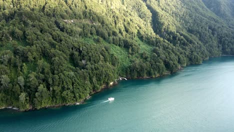 Aerial-pan-right-of-a-boat-near-the-shore-of-Lake-Todos-los-Santos,-southern-Chile