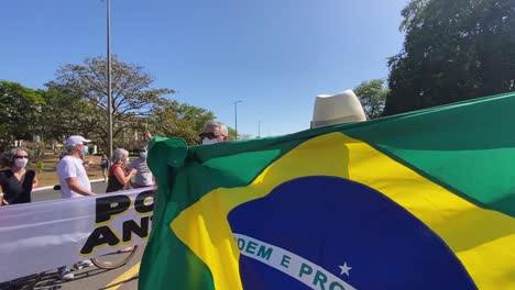 Ein-Mann,-Der-In-Die-Nationalflagge-Brasiliens-Gehüllt-Ist,-Dreht-Sich-Um-Und-öffnet-Die-Flagge-Beim-Protest-In-Der-Stadt-Brasilien-Gegen-Die-Tötungen-Zweier-Männer-Im-Amazonasgebiet-In-Den-Amazonasgebieten