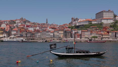 Langsamer-Schwenk-Um-Die-Gebäude-Von-Porto-Rebeira-Zur-Historischen,-Berühmten-Metallbrücke-Ponte-Luis-An-Einem-Strahlend-Sonnigen-Sommertag-Mit-Ausflugsbooten,-Die-Im-Fluss-Duoro-Schwimmen,-Portugal-2022