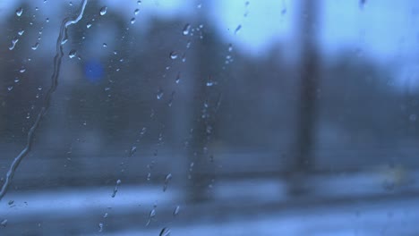 Wassertropfen-Auf-Dem-Fenster,-Während-Der-Defokussierte-Zug-überholt-Wird,-Wintertag