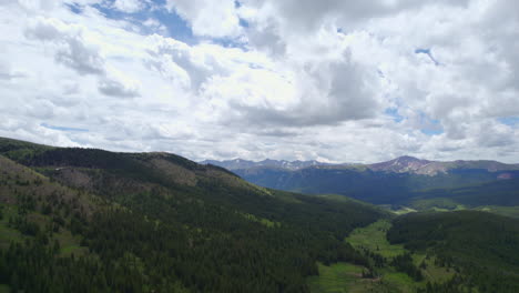 HD-Aerial-Drone-Shot-Of-Peaceful-Idyllic-Alpine-Forest-Mountain-Valley-Landscape-With-Puffy-White-Clouds-During-Beautiful-Summer-Day