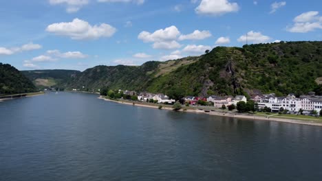 Aerial-flying-drone-shot,-panning-right,-of-the-Rhine-River-Valley-and-Old-Architecture---including-medieval-castles,-old-buildings,-and-natural-forested-hills