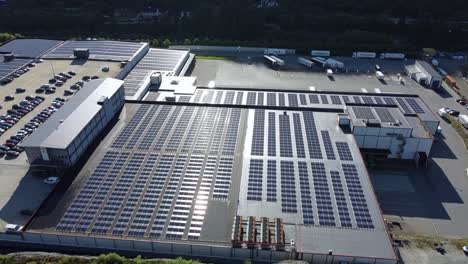 Massive-solar-park-with-7546-panels-n-Asko-warehouse-Bergen---Aerial-orbiting-right-with-beautiful-reflections-passing-on-panels-surface
