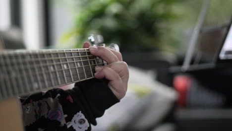 CLOSE-UP-Woman-Changing-Chords-On-A-Acoustic-Guitar-Fretboard