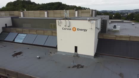 Corvus-Energy-Logo-Und-Firmengebäude-In-Bergen,-Norwegen-–-Luftaufnahme,-Die-Sich-Langsam-Um-Das-Logo-Auf-Dem-Dach-Dreht-–-Batterien-Für-Elektrofahrzeuge-Und-Industrielle-Nutzung