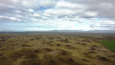 drone-panshot-to-the-left-over-spectaculair-landscape-with-little-hills-in-Iceland-4k