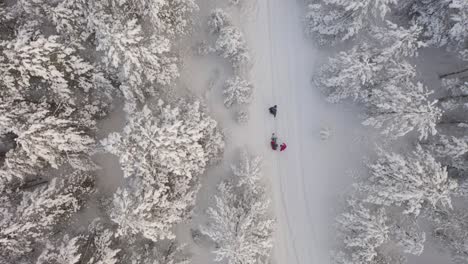 Drohnenvideo-Einer-Tracking-Familie,-Die-Im-Schnee-Unterwegs-Ist