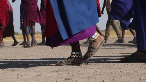 A-slow-motion-clip-of-a-group-of-Maasai-woman-dancing,-celebrating-and-greeting-during-migration-season-at-a-low-angle-in-the-Ngorongoro-crater-Tanzania