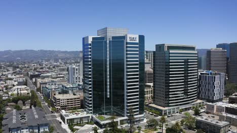 Aerial-view-approaching-the-blue-shield-headquarters,-in-sunny-Oakland,-USA---rising,-drone-shot