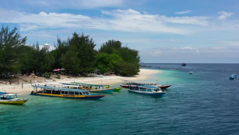 Barcos-Turísticos-Anclados-En-Una-Playa-Tropical-De-Arena-Blanca-En-La-Isla-Gili-Trawangan-En-Un-Día-Soleado-De-Verano,-Antena