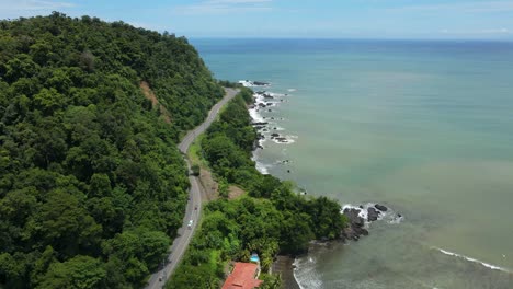 aerial-drone-of-road-between-mountain-and-beach-in-Jaco,-Costa-Rica