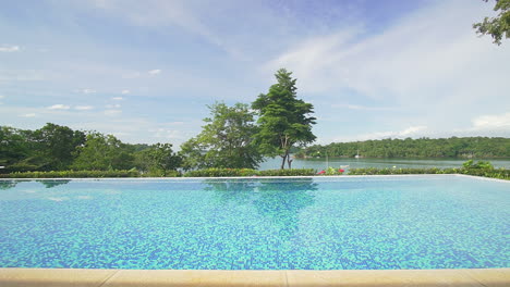 Wunderschöner-Poolblick-In-Einem-Luxuriösen-Resort-Mit-Blick-Auf-Bäume,-Himmel-Und-Meer