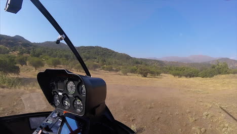 Helicóptero-Volando-Bajo-Y-Cerca-Del-Suelo-Levantando-Polvo,-Disparando-Desde-Adentro,-En-Full-Hd-A-60-Fps