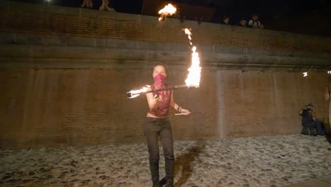 Zeitlupen-Nahaufnahme-Und-Schwenken-Von-Sich-Drehenden-Feuerstäben-Eines-Mädchens,-Das-Ein-Kopftuch-über-Dem-Gesicht-Trägt