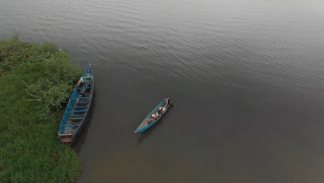 Aerial-shot-of-a-traditional-wooden-fishing-boat-in-Africa-launching-off-the-shores-of-Lake-Victoria