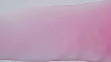 Pink-bubble-water-flowing-from-right-to-left-on-a-white-paper-background