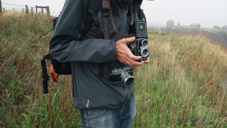 A-photographer-with-two-cameras-on-an-overcast-day-in-Scotland