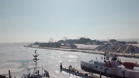 Drohnenaufnahme-Von-Booten-In-Einem-Zugefrorenen-Hafen-Und-Steinbruch-Am-Eriesee-In-Ontario,-Kanada,-Mitten-Im-Winter