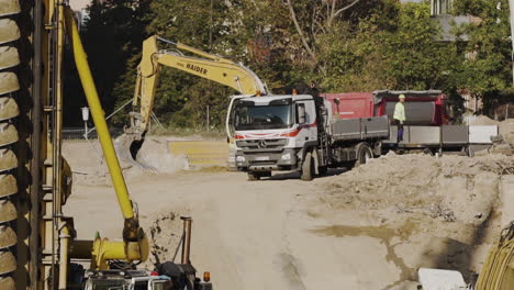 Excavator-and-a-truck-on-a-construction-site-in-Vienna,-Austria,-working-on-dirt-removal-and-preparation-for-building