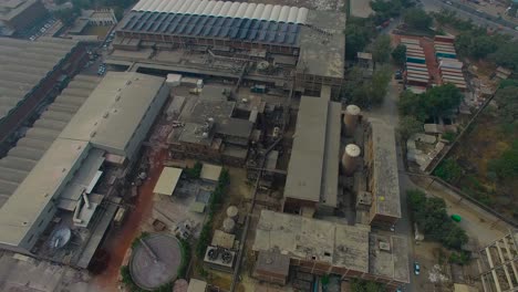 A-factory-top-pan-down-from-drone-camera,-Bombay,-India,-showing-roofs-of-the-factory