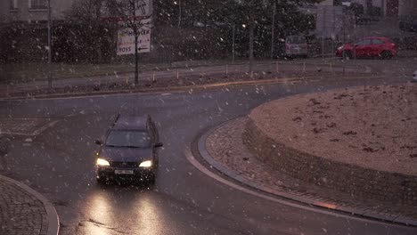 Few-cars-driving-on-roundabout-during-snowing---slow-motion