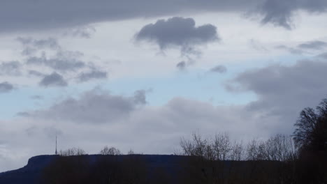Sich-Bewegende-Wolken-Am-Himmel,-Silhouetten-Von-Bäumen-Und-Büschen-Im-Vordergrund