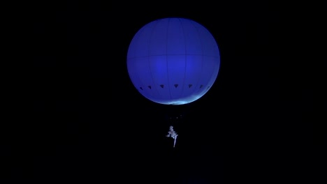 Artistic-performance-with-a-person-hanging-from-a-large-balloon-in-the-sky-at-the-Eternal-Voyages-event-around-Pafos-Castle-and-harbour-in-Cyprus