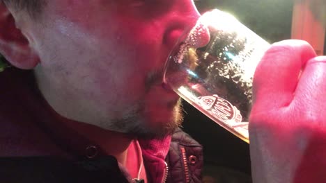 Man-drinking-a-pint-of-beer-in-a-pub-garden-at-night