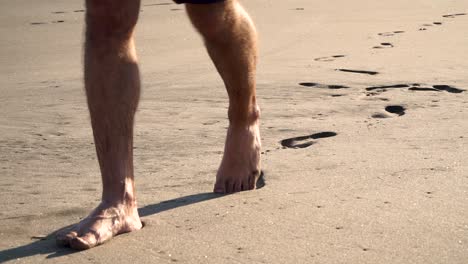 SLOWMO---Close-up-of-feet-walking-on-sand-and-leaving-footprints-behind