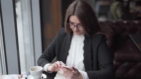 Mujer-Tomando-Café-Mientras-Trabaja-Desde-El-Teléfono-Celular