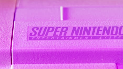 Logotipo-En-La-Consola-Vintage-Super-Nintendo-En-Luz-Púrpura-Desliza-Hacia-La-Izquierda