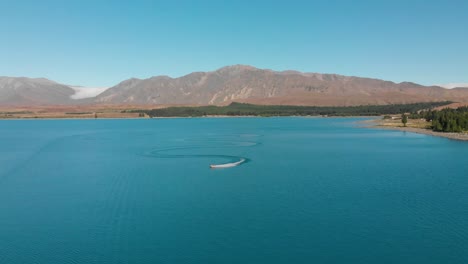 SLOWMO---Jet-Ski-on-Beautiful-Turquoise-Blue-Water---Lake-Tekapo,-New-Zealand---Aerial