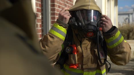 Firefighter-puts-on-a-fireproof-hood-for-going-into-a-burning-building-with-smoke