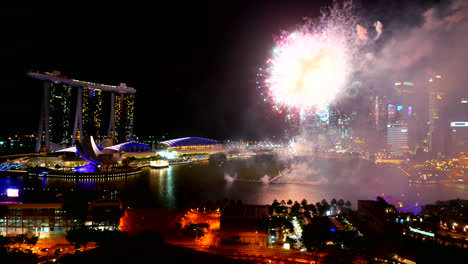 Fireworks-in-the-marina-bay-in-Singapore,-Marina-Bay-Sands-luxury-hotel-and-skyscrapers