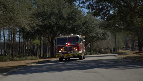 Firetruck-driving-on-a-residential-street-with-emergency-lights-flashing-to-respond-to-a-fire