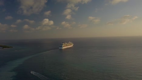 Aerial-view-of-the-cruise-ship-sailing-into-the-big-blue-ocean-away-from-the-dock-on-the-island-4K