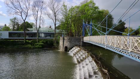 Alte-Verzierte-Eisenbrücke,-Die-An-Einem-Ruhigen,-Sonnigen-Tag-Eine-Fließende-Abnutzung-In-Einem-Park-In-Leamington-Spa-überquert
