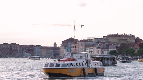 Zufälliger-Wasserbootverkehr-Auf-Dem-Canal-Grande-In-Venedig-Mit-Blick-Auf-Die-Stadt-Im-Hintergrund