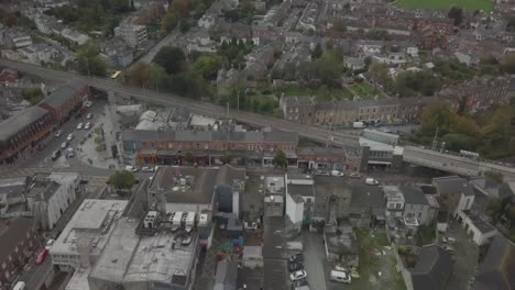 Aerial-shot-of-a-suburban-town-street-on-the-outskirts-of-Dublin-City-centre,-some-late-traffic-moving