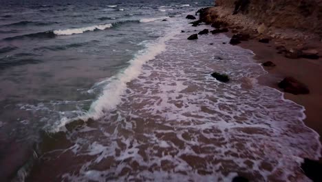 Schöne-Wellen-Am-Strand,-Die-Bei-Sonnenuntergang-Auf-Die-Felsen-Schlagen