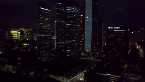 Tiro-De-Drone-De-Círculo-Aéreo-De-Rascacielos-De-Singapur-En-La-Noche