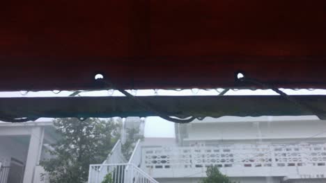 Rain-water,-rain-drops-dripping-from-tarp-outside-homes-in-residential-neighbourhood