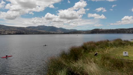 Drone-Volando-Hacia-Atrás-Revelando-Dos-Kayacks-En-El-Lago-San-Pablo-Cerca-De-La-Orilla