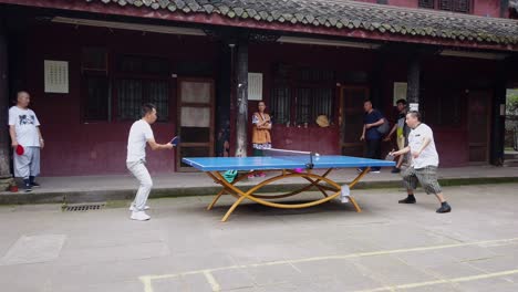 Chengdu,-China---July-2019-:-Man-and-woman-playing-ping-pong-in-the-courtyard-of-Wenshu-Monastery-in-Chengdu,-Sichuan-Province