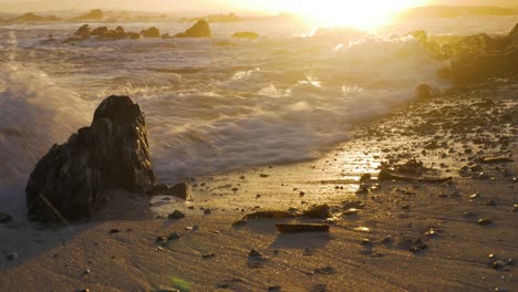Kleine-Wellen,-Die-Während-Des-Goldenen-Sonnenuntergangs-Im-Hintergrund-Auf-Den-Strand-Krachen