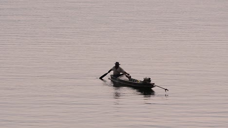 Fisherman-silhouetting-as-he-is-casting-and-drawing-his-net-in-the-River-before-dark